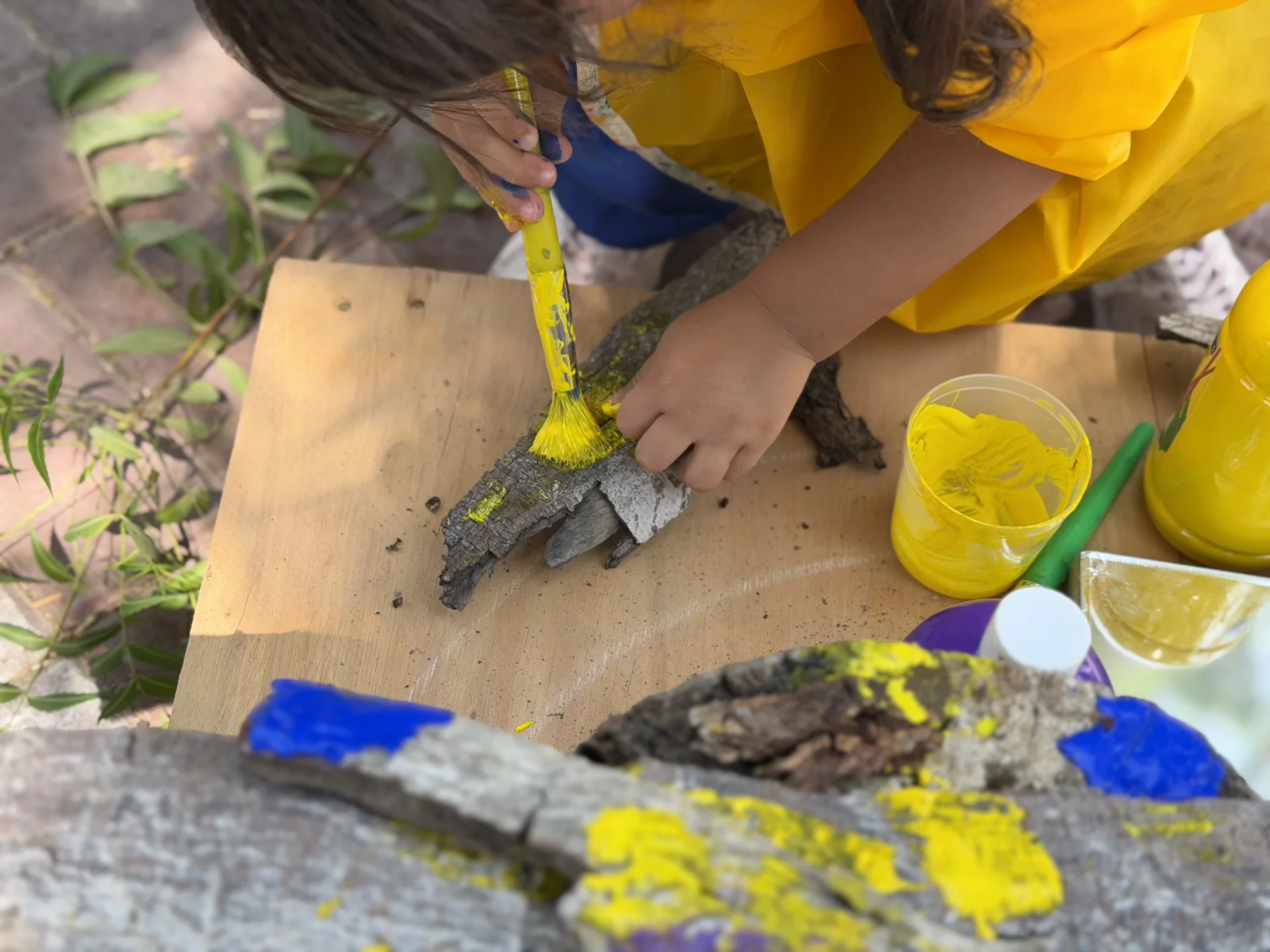 Close-up of hands painting bark | Beginnings Forest Montessori Dubai Close-up of hands painting bark at Beginnings Forest Montessori in Muhaisnah, Dubai.