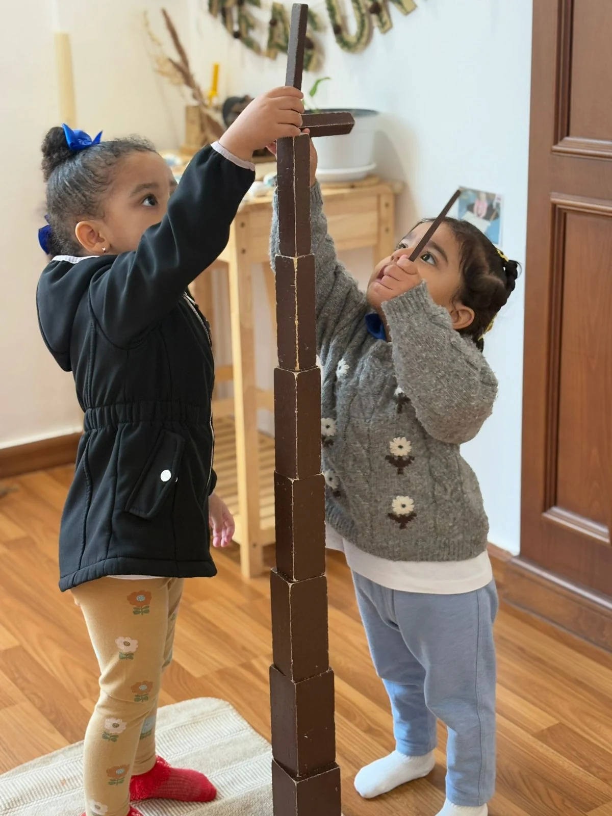 Two children building with brown stair blocks.